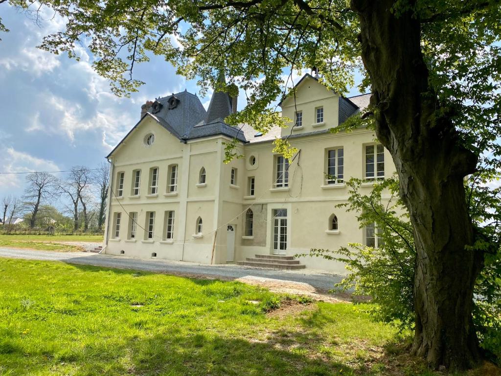 La RemuéeManoir de L'Oiselière的前方有树的大白色房子