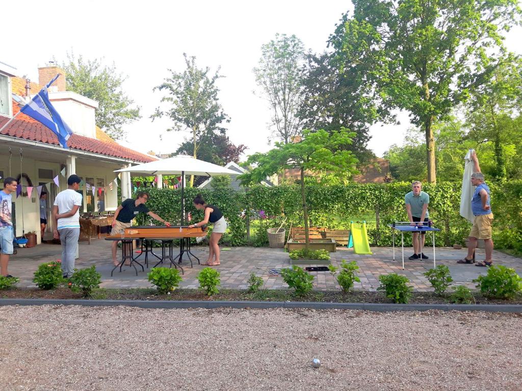 un grupo de personas de pie alrededor de una mesa en un patio en 't Zeeuwse licht en Middelburg