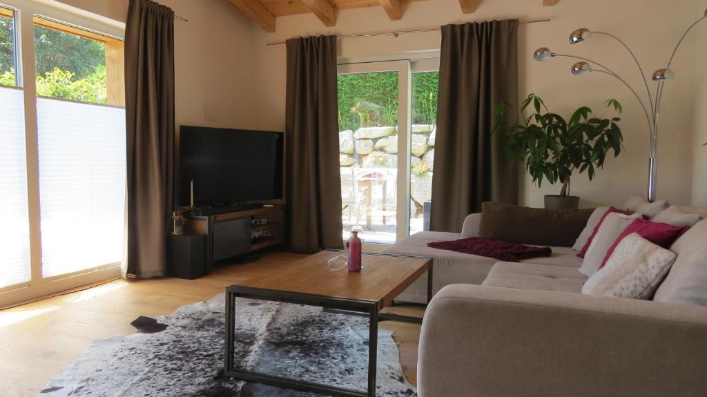 ein Wohnzimmer mit einem weißen Sofa und einem Fernseher in der Unterkunft Chalet Hackl in Sautens