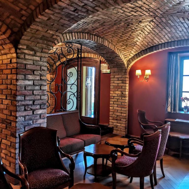 a room with chairs and a brick wall at Hotel Dvorac Jurjevec in Lekenik