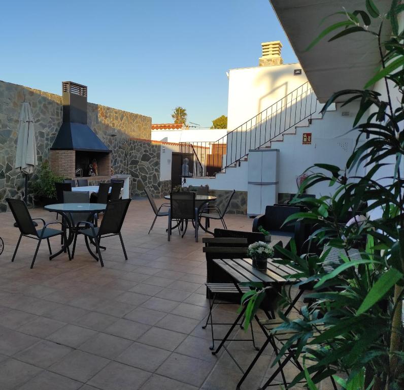 a patio with tables and chairs and a fireplace at Lo Trabucador Casa nueva en el corazón del Delta in Poblenou del Delta