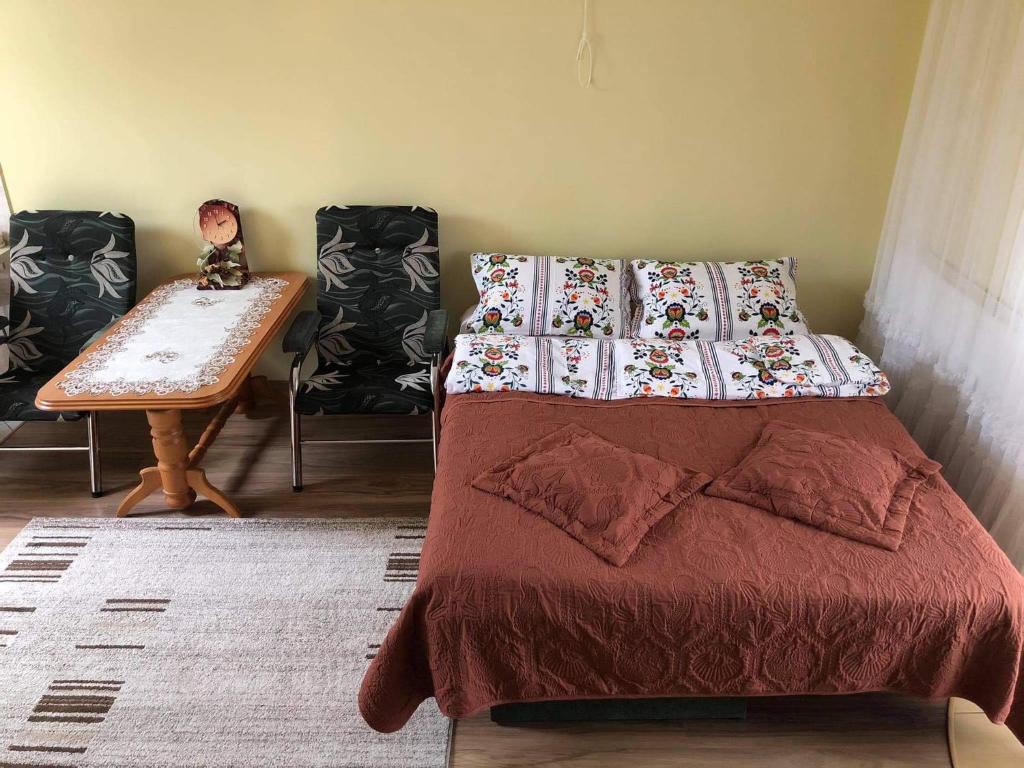 a bedroom with a bed and a table with chairs at "Pokoje u Ireny"-pokój z aneksem in Sztutowo