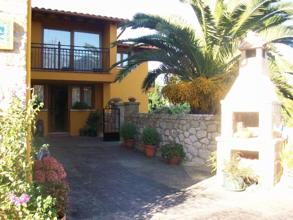 a yellow house with a palm tree and a building at La Canal in Ubiarco