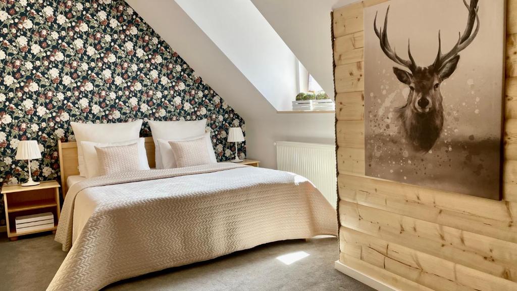 a bedroom with a bed with a deer head on the wall at Jaszowianka Best For You in Ustroń