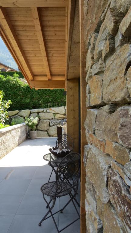 eine Terrasse mit 2 Stühlen und einer Steinmauer in der Unterkunft Chalet Hackl in Sautens