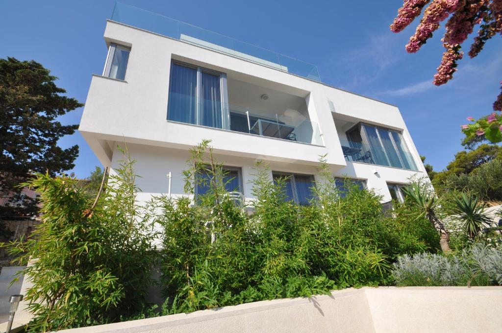 une maison blanche avec des plantes devant elle dans l'établissement Design apartment 1ˇˇˇˇ, à Mali Lošinj