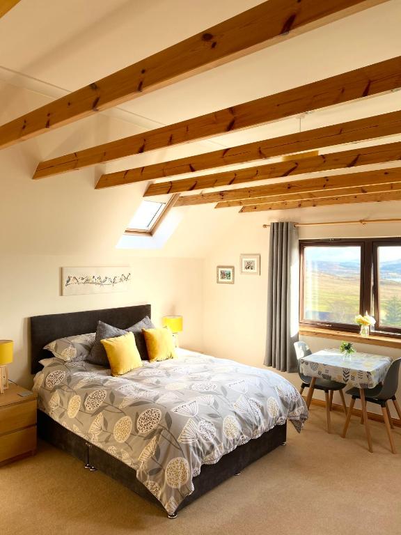 Un dormitorio con una cama y un escritorio y una ventana. en Tor View, en Portree