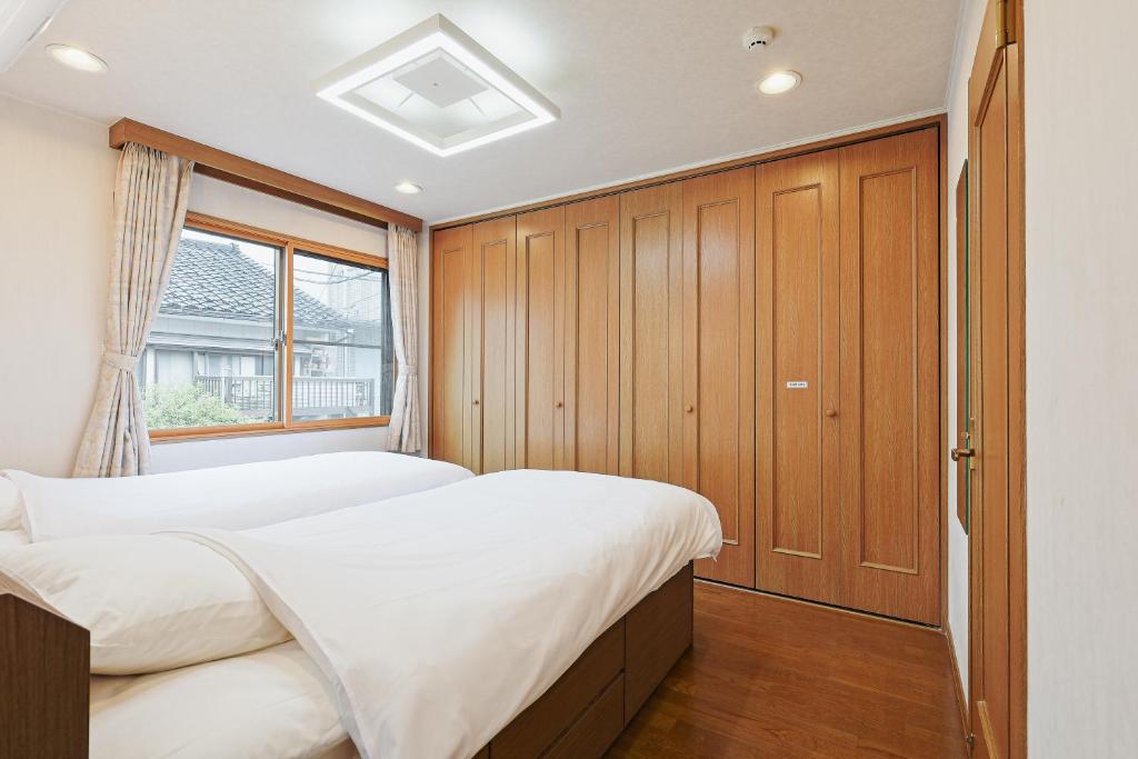 een slaapkamer met twee bedden en een raam bij Mon Petit Chat in Kanazawa