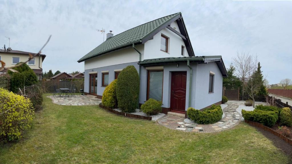 a small white house with a red door at MB House Sarbinowo in Sarbinowo