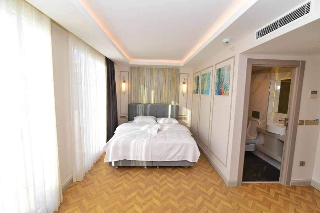1 Schlafzimmer mit einem weißen Bett und einem Badezimmer in der Unterkunft Serai Hotel in Istanbul