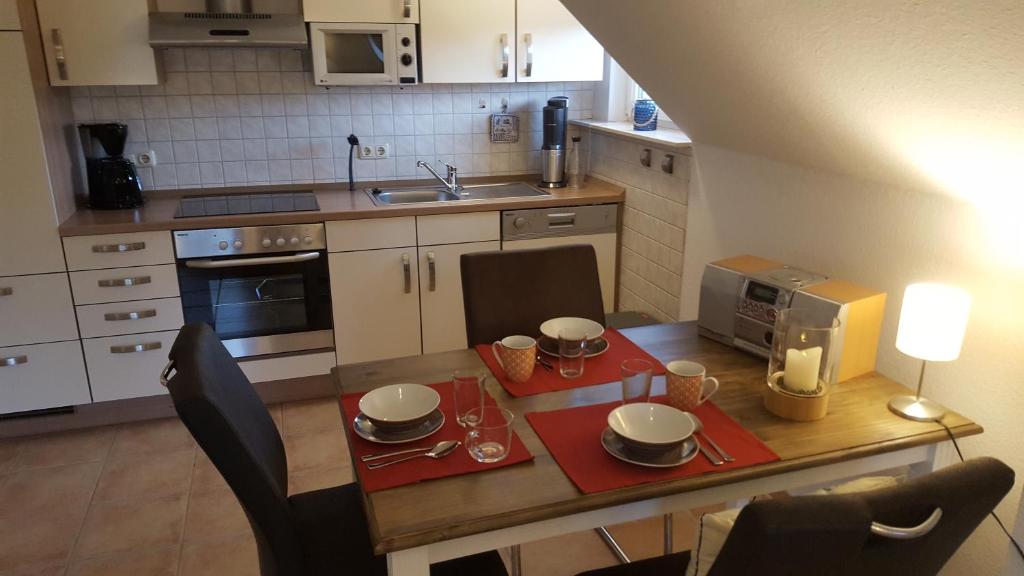 eine kleine Küche mit einem Tisch und einer Mikrowelle in der Unterkunft Trekvogels Hörn in Dornum