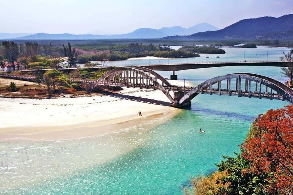 a bridge over a beach and a bridge over water at ReCanto dos Passáros - Guaratiba in Pedra de Guaratiba