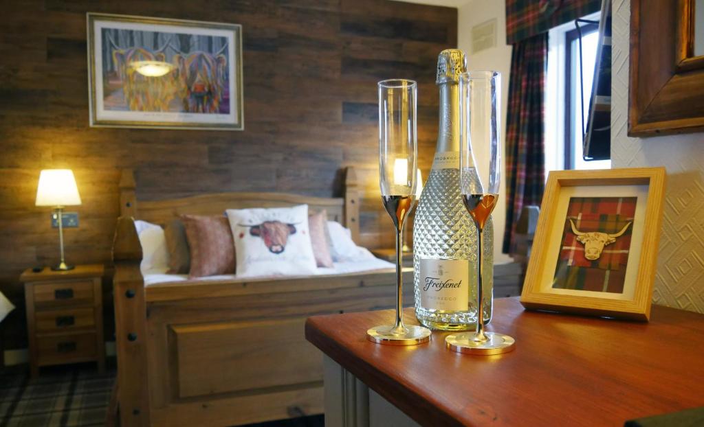 a bottle of wine on a table in a room with a bed at Ardentorrie Guest House in Inverness