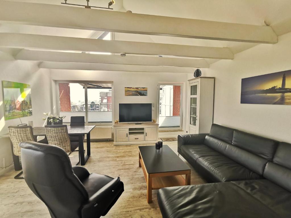 uma sala de estar com um sofá e uma televisão em Sonnendeck Nordsee em Horumersiel