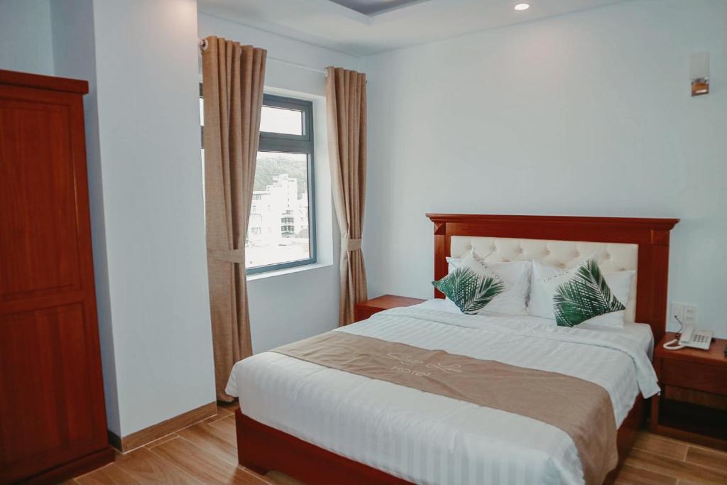 a bedroom with a large bed and a window at Lam Hồng Apartment & Hotel in Nha Trang
