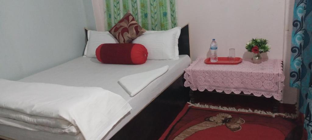 邦帝培的住宿－Unique Hotel and Lodge - Pleasure of Homely Stay -，一间小卧室,配有两张床和一张桌子