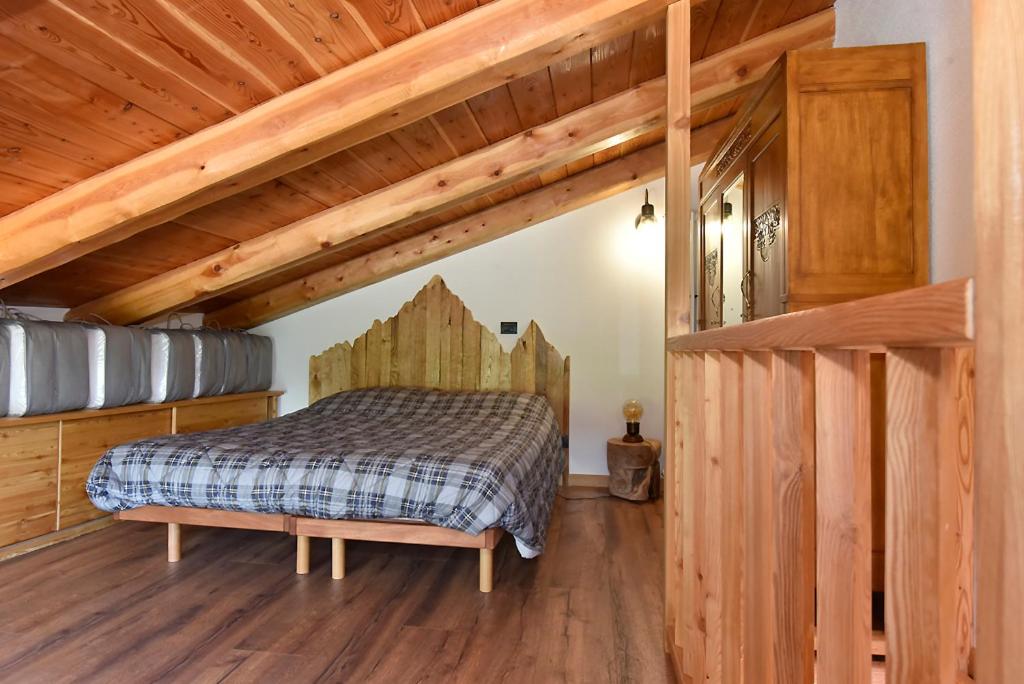 um quarto com uma cama e um tecto de madeira em ALTESTANZEOSTANA em Ostana