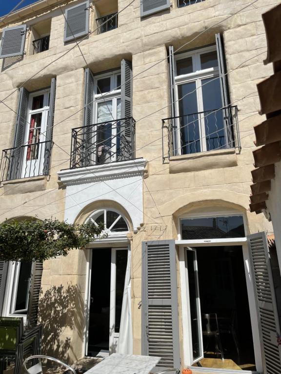 a building with windows and balconies on a street at Maison Capucine in Mèze