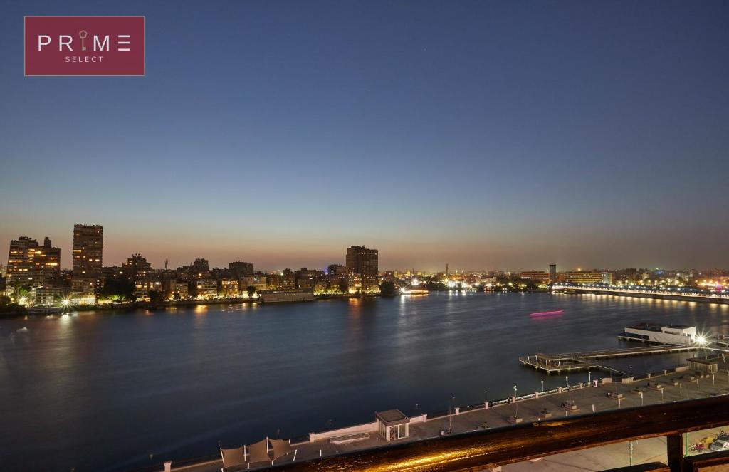 a view of a river with a city at night at Prime Select Arkadia Nile View in Cairo