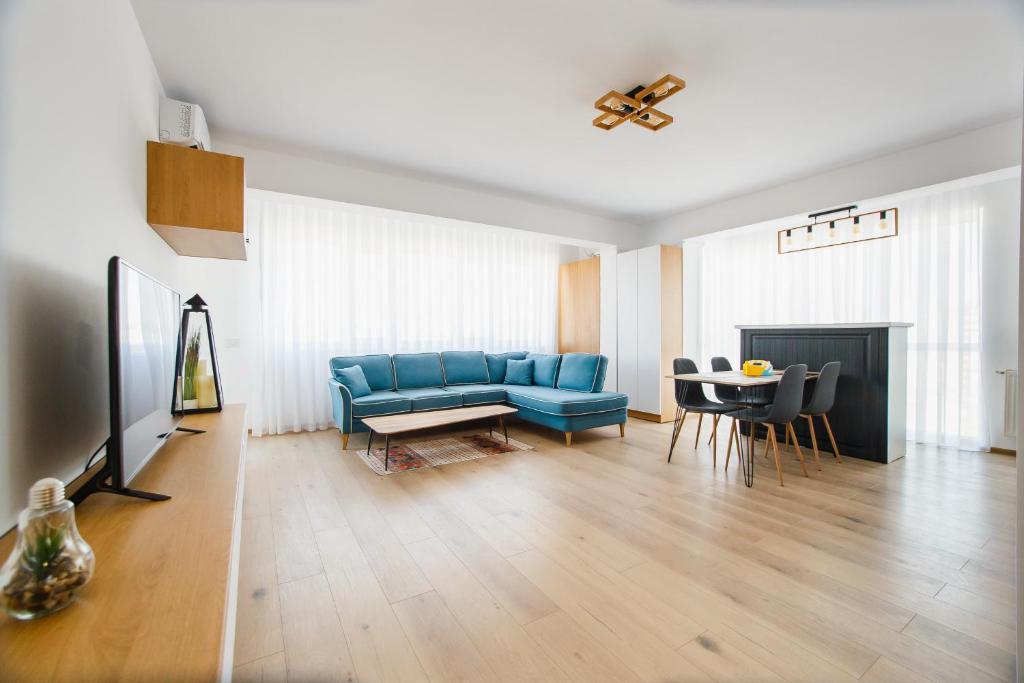 sala de estar con sofá azul y mesa en Panorama Views - Spacious Central Apartment en Oradea