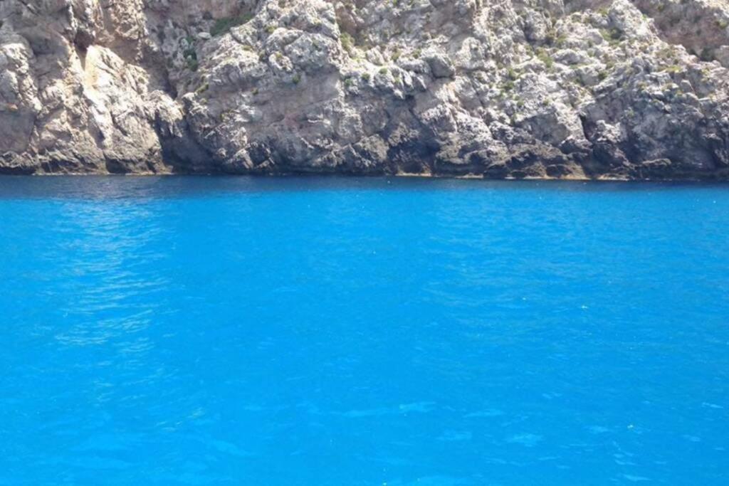 a large blue lake next to a rocky cliff at Vivi Marettimo in Marettimo