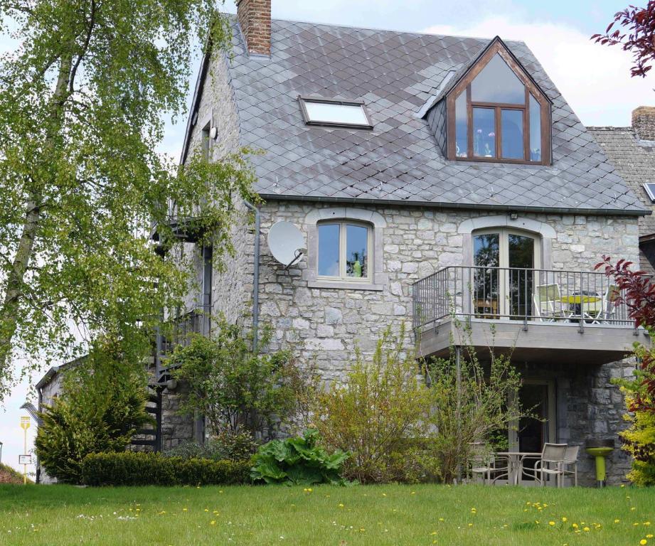 een stenen huis met een veranda en een balkon bij Foyti in Dinant