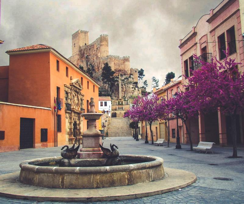 una fuente en una calle con un castillo en el fondo en AIRAM Home ARAGON, 7, en Almansa