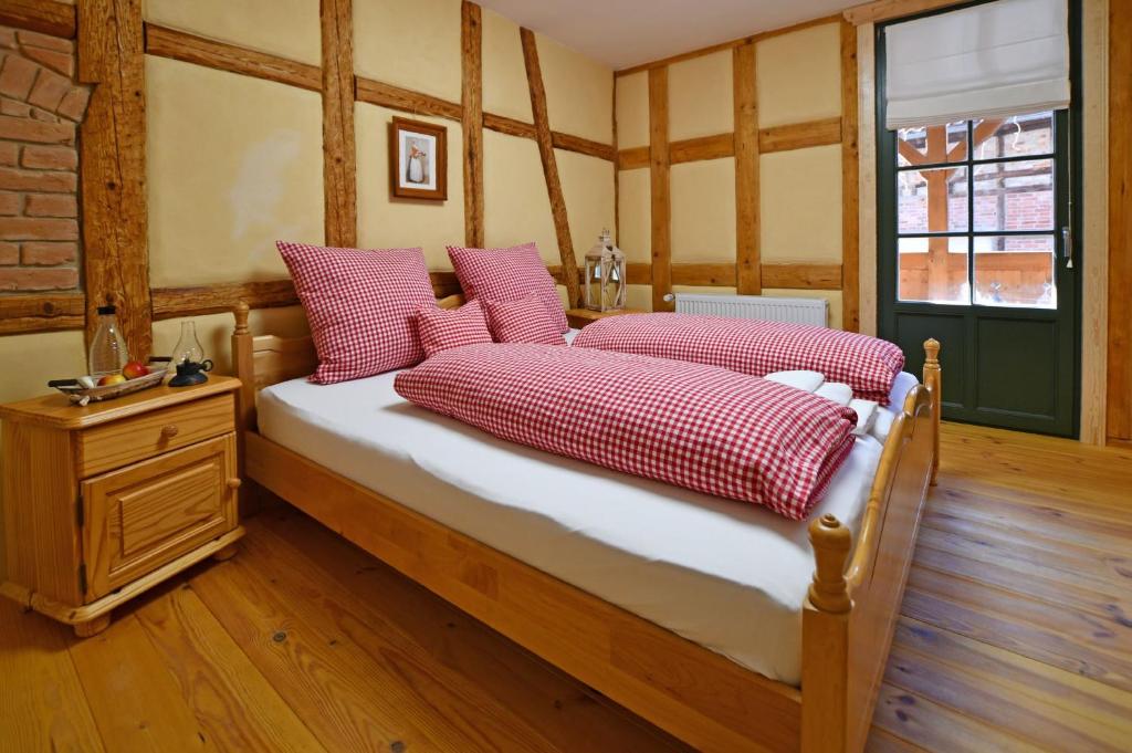 una camera da letto con un letto con cuscini rossi e bianchi di Naturhof-Papiermühle 2 Bett-Zimmer Rosenrot a Bollberg