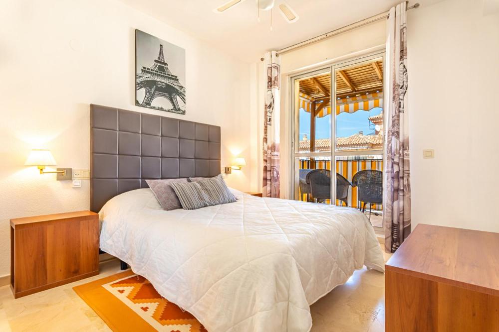 1 dormitorio con cama grande y ventana grande en Appartement idéal pour chiller au soleil !, en Fuengirola