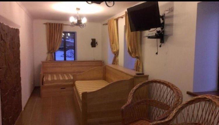 a living room with a couch and a flat screen tv at Дом для отдыха в лесу in Berëzovka
