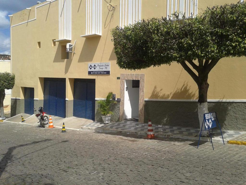 a building with a tree in front of a building at Pousada CERTRI in Triunfo