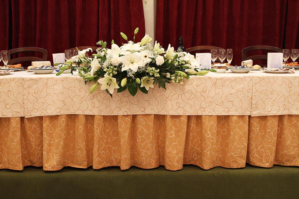 a table with a centerpiece of white flowers on it at Hotel Begoña Park in Gijón
