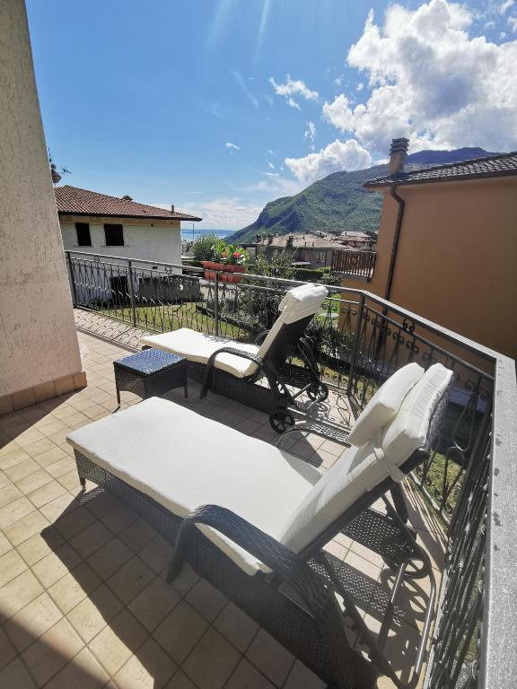 a patio with two chairs and a table on a balcony at Casa Pina in Tignale