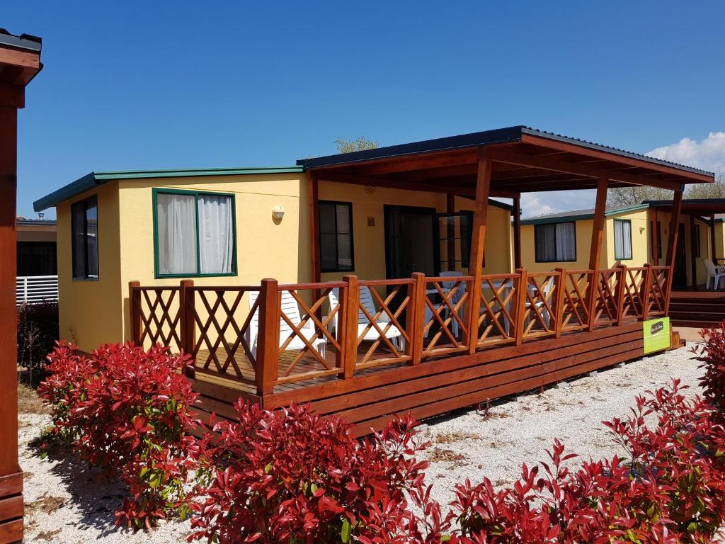 a house with a large deck in the sand at FKK Ulika - Naturist Mobile Homes Eden in Poreč