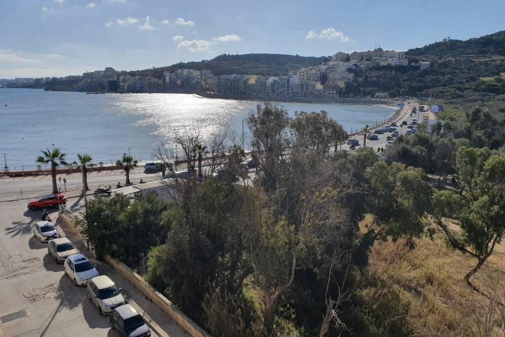 une vue aérienne sur une plage avec des voitures garées dans l'établissement The Diamond Apartment, à San Pawl il-Baħar