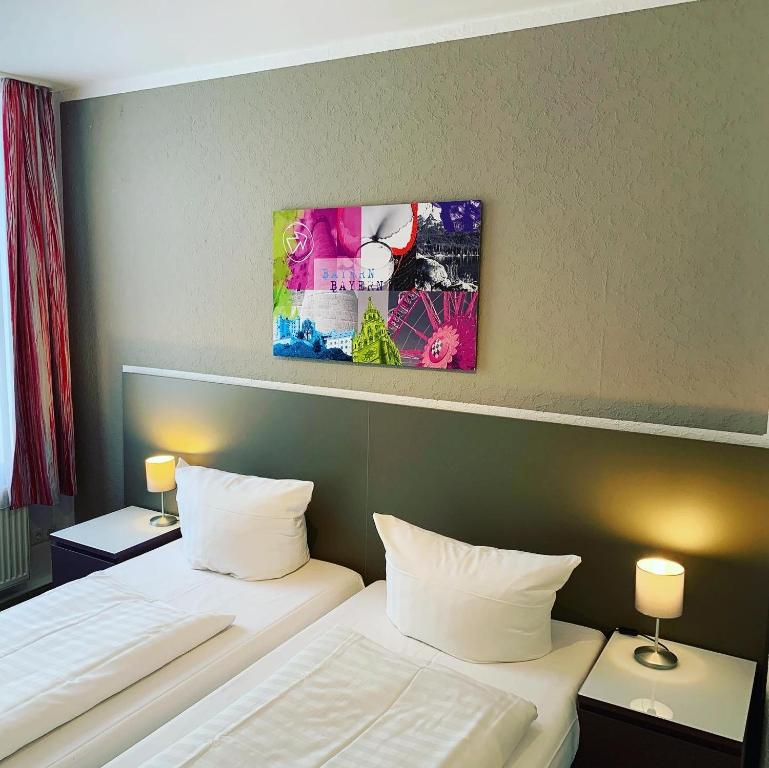 a hotel room with two beds and a painting on the wall at Pension Belo Sono in Munich