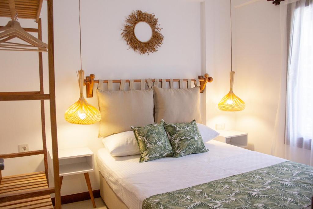 ein Schlafzimmer mit einem Bett mit zwei Kissen und einem Spiegel in der Unterkunft Nova Aparts in Akyaka