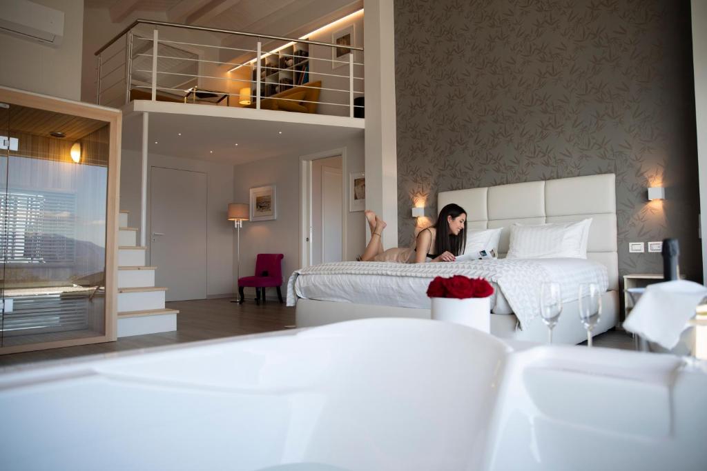 kobieta siedzi na łóżku w sypialni w obiekcie Bellavista B&B di Charme w mieście Macchiagodena