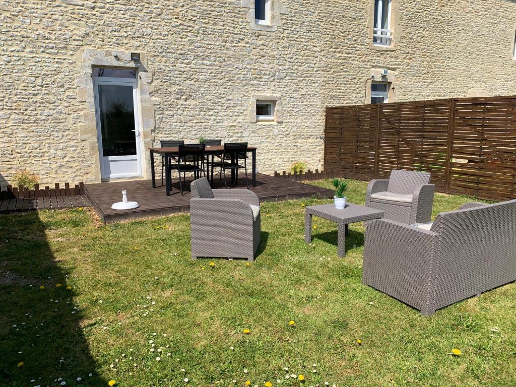 a group of chairs and tables in a yard at Gîte avec jardin à 1,5 km des plages du débarquement in Tracy-sur-Mer