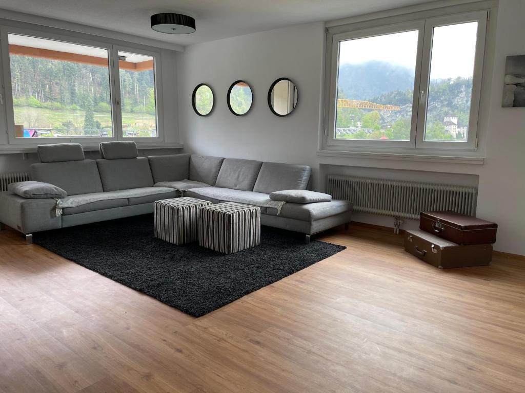 a living room with a couch and two windows at Skyloft Apartment Feldkirch in Feldkirch