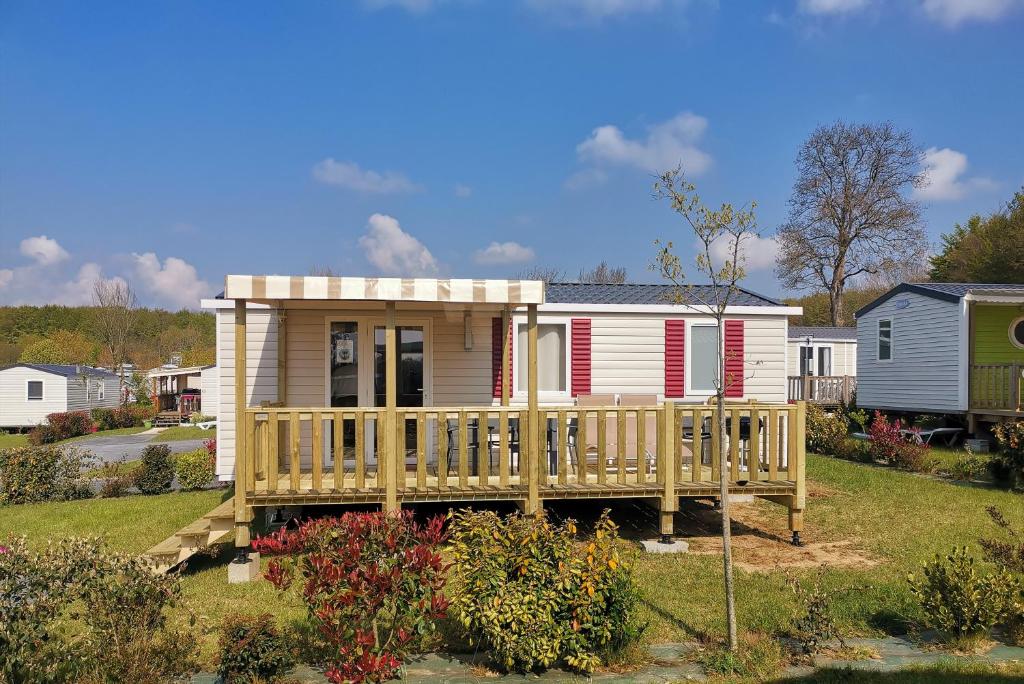 Casa pequeña con terraza de madera en un patio en Mobil Home 6 pers, Normandie, Le P'tit Boujou en Litteau
