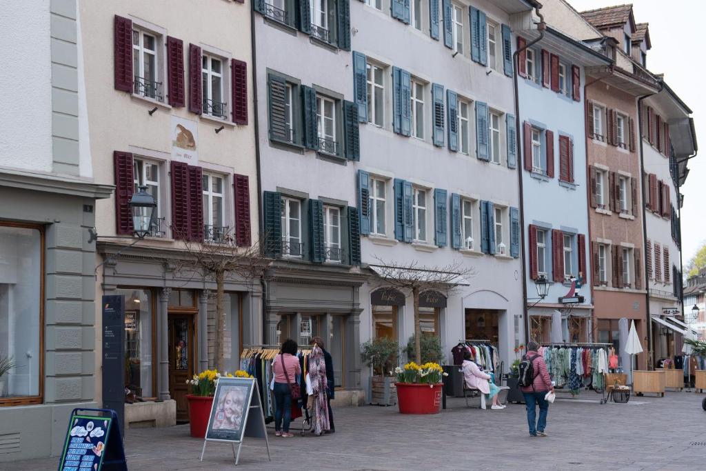 um grupo de pessoas andando por uma rua com edifícios em Unterkunft "Rathaus" Altstadt, Rheinfelden Schweiz em Rheinfelden