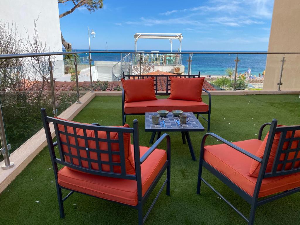 d'une terrasse avec 2 chaises et une table et vue sur l'océan. dans l'établissement Villa Del Mar Bord de mer Palm Beach Cannes, à Cannes