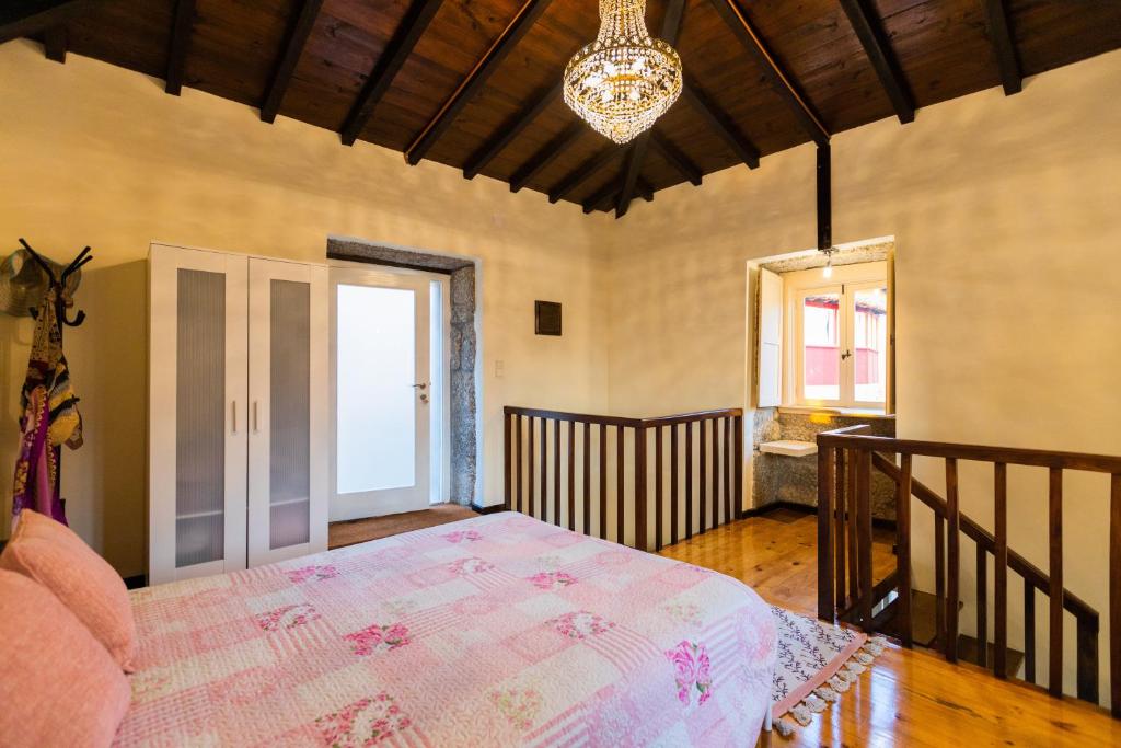 1 dormitorio con cama y lámpara de araña en Quinta dos Campos - Chalé, en Braga