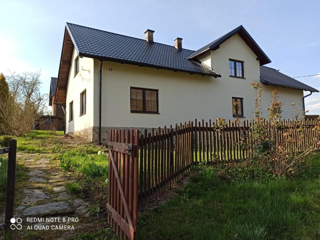 a white house with a wooden fence at Chalupa Hrabišín in Šumperk