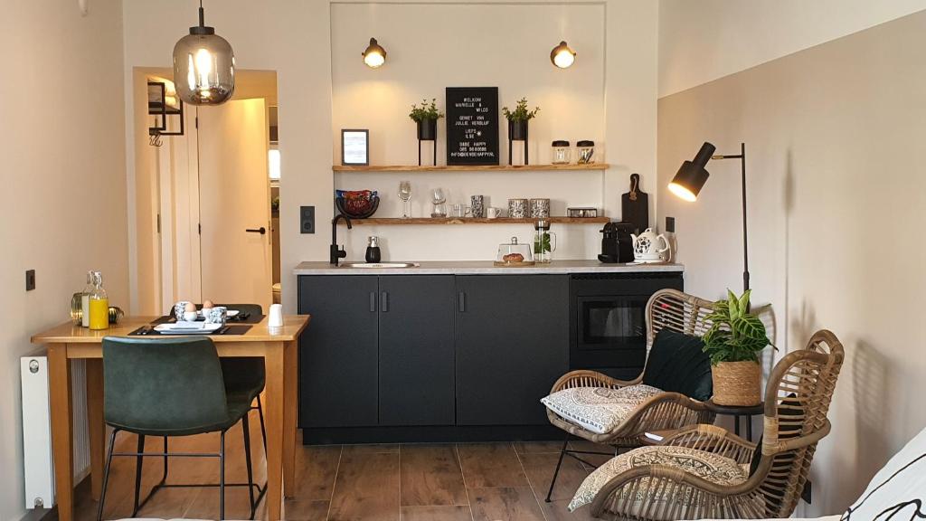 a kitchen with a table and chairs and a counter at B&Be Happy in Berg en Terblijt