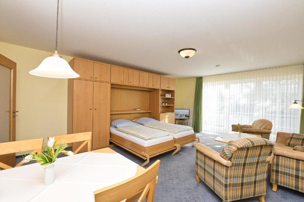 Appartement Rehn Büsum في بوسوم: غرفة معيشة مع سرير وغرفة طعام