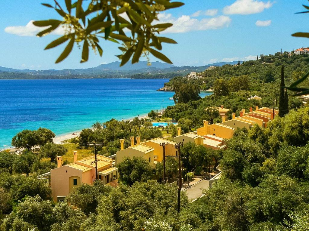 Blick auf den Strand, die Gebäude und das Meer in der Unterkunft Barbati Bay Elegant Beach Apartments by Hotelius in Barbati