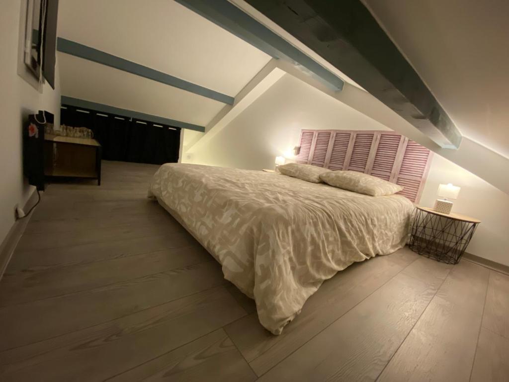 a bedroom with a large bed in a attic at Beau T2 cosy Entre Gap et le lac de Serre-ponçon in La Bâtie-Neuve