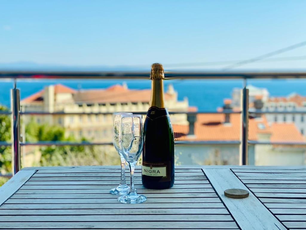 uma garrafa de vinho e um copo de vinho numa mesa em Apartment AlMare em Opatija
